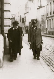 Gustave Charpentier (à gauche) et Ermend Bonnal (à droite) à Paris, devant la Schola Cantorum, 269 rue Saint-Jacques. Gustave Charpentier est le compositeur de l'opéra Louise.